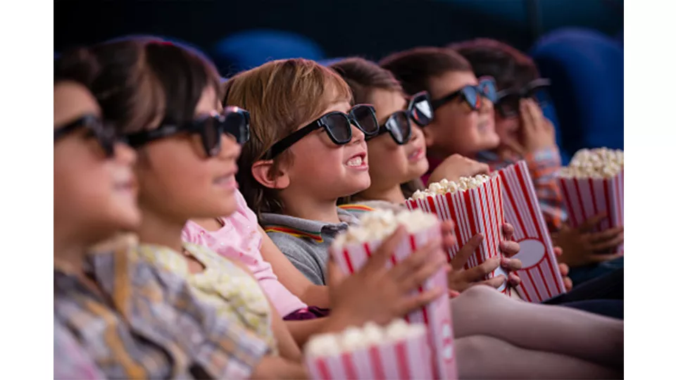 enfants au cinema avec des lunettes 3D et des popcorns